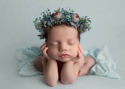 baby wearing a flower headband, frog