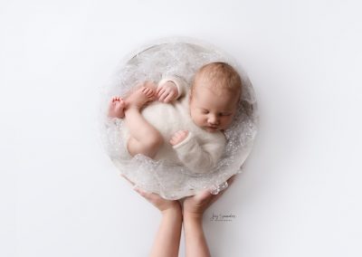baby in a bowl with parents hands